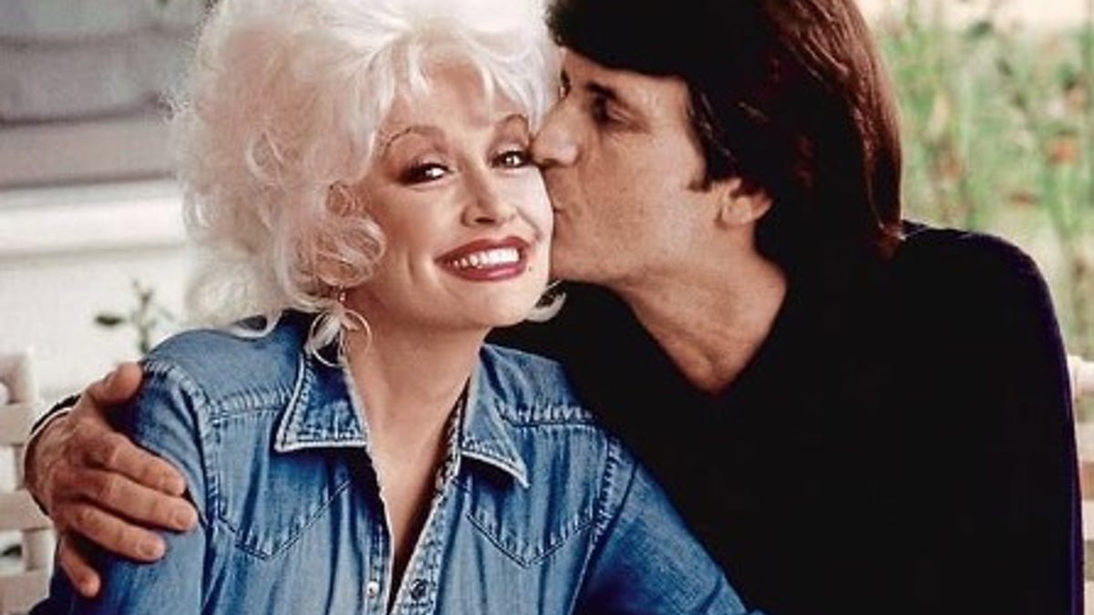 dolly parton being kissed on the cheek by husband carl
