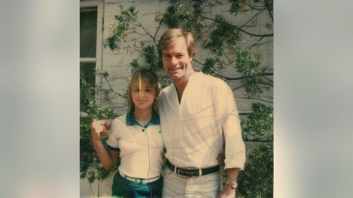 Stephen Collins wearing a white shirt and pants with his arm around April Price wearing a white shirt and blue pants.