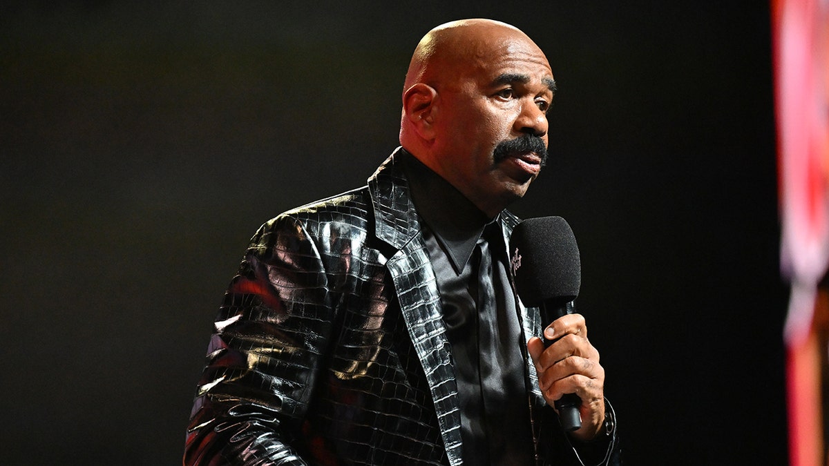 Steve Harvey is on stage with the microphone