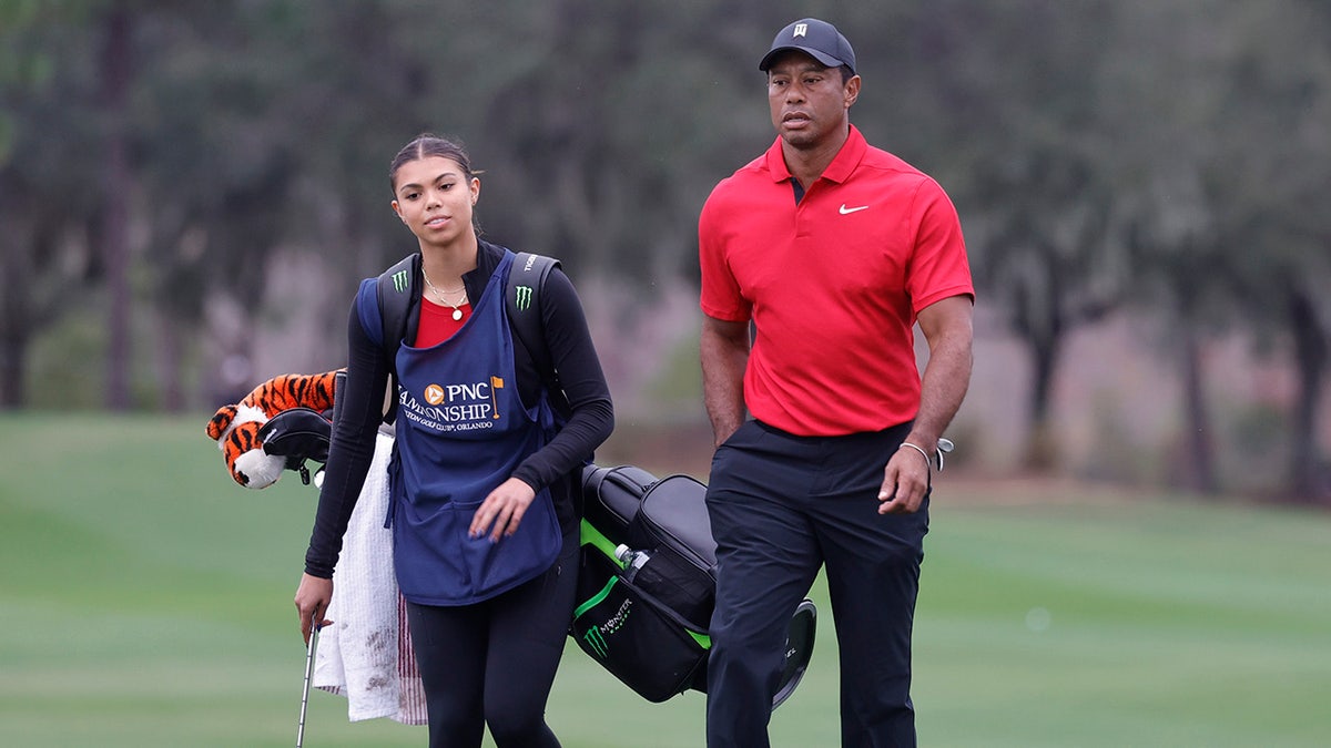 Tiger e Sam Woods andando em campo de golfe