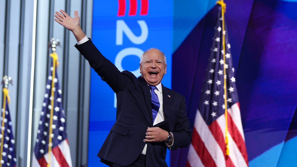 Governor Tim Walz on the stage of DNC, the flag behind him