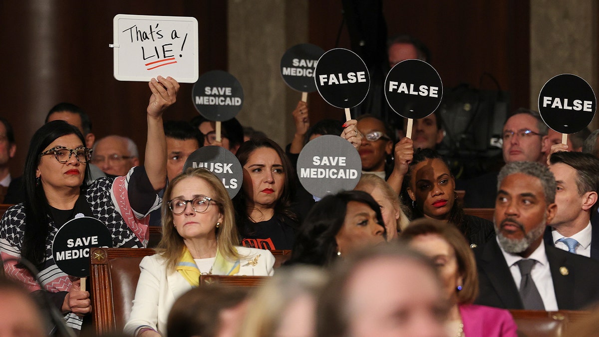 El representante Tlaib sostiene una pizarra en el discurso de Trump a una sesión conjunta del Congreso