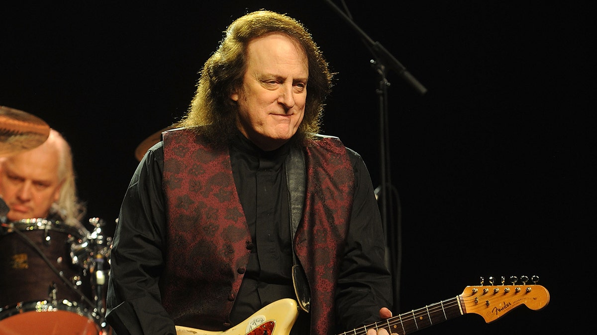 Tommy James plays guitar on stage