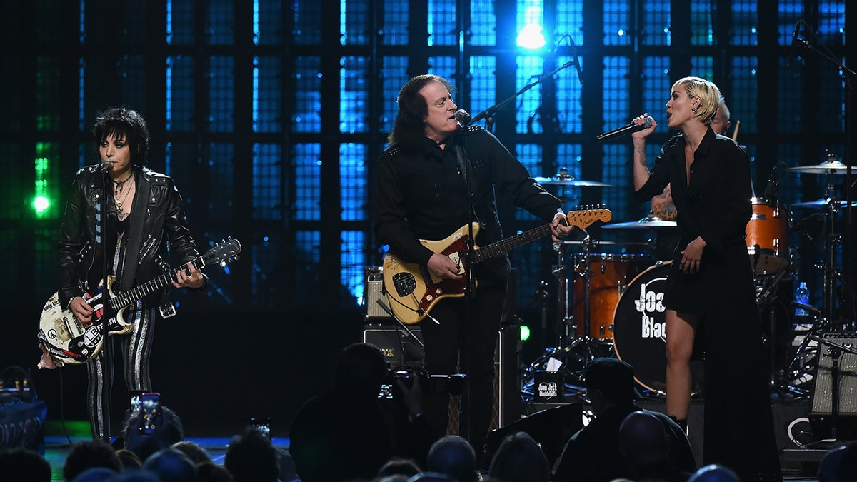 Inductee Joan Jett of Joan Jett and The Black Hearts (L) performs with musicians Tommy James (C) and Miley Cyrus during the 30th Annual Rock And Roll Hall Of Fame