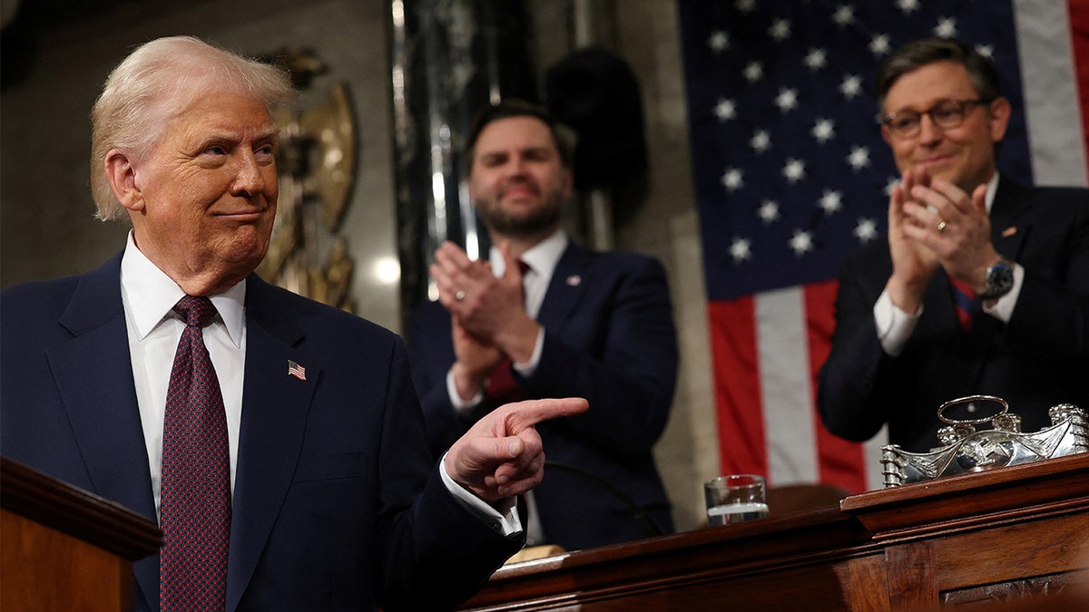 Trump on dais, pointing, VP Vance, Speaker Johnson behind him