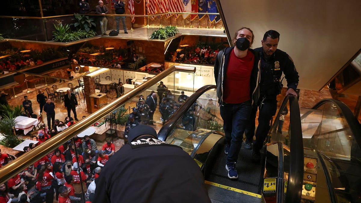 A protestor from the group, Jewish Voice for Peace, who protested inside Trump Tower in support of Columbia graduate student Mahmoud Khalil is escorted out by New York Police officers after being arrested, Thursday, March 13, 2025, in New York. (AP Photo/Yuki Iwamura)