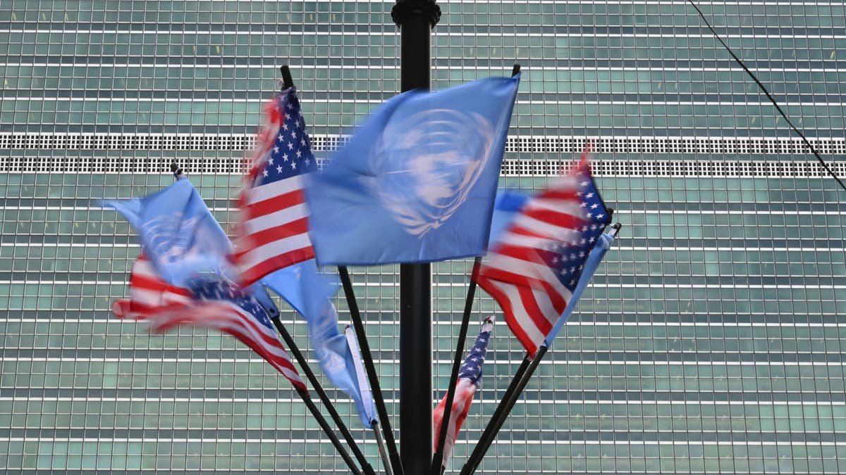 Os Estados Unidos e as bandeiras da ONU voam para fora da sede da ONU.