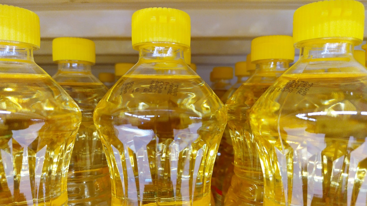 Bottles of vegetable oils with yellow caps are shown.