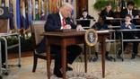 President Donald Trump signs an executive order in the East Room of the White House in Washington, Thursday, March 20, 2025. (AP Photo/Ben Curtis)