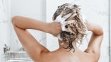 Female Taking Shower And Washing Hair with shampoo