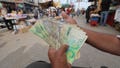 A man holds a wad of Israeli shekels in Gaza. - Fox News