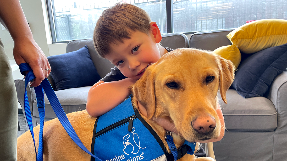 evan leans his head on service dog kalvin