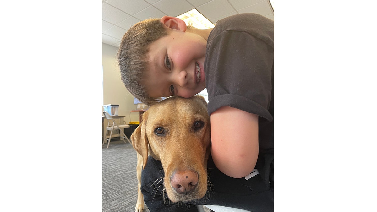 evan and service dog put their heads together