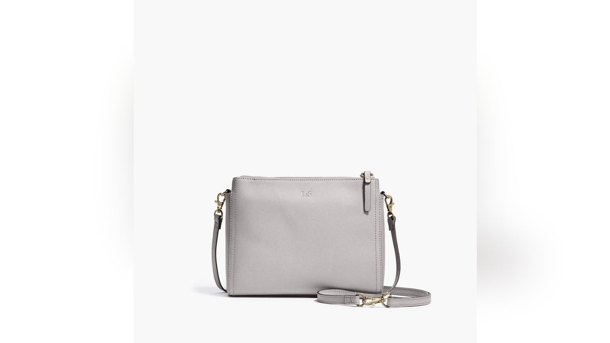 Made from genuine leather, this bag features multiple compartments and a detachable strap, allowing it to be converted to a clutch.