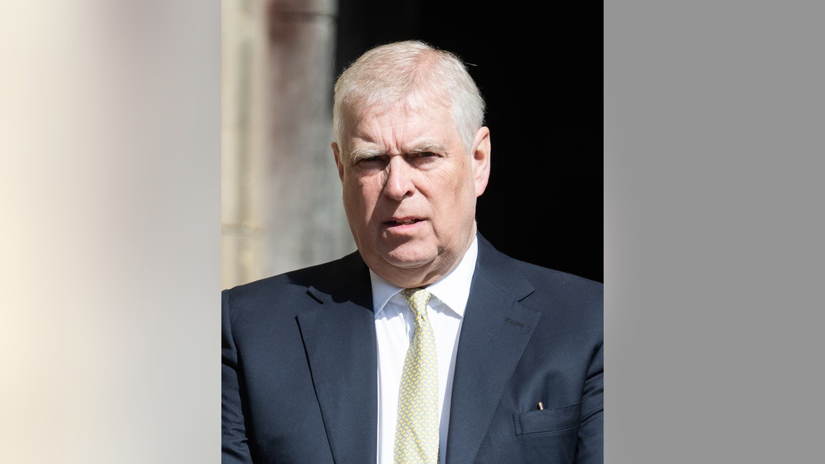 Prince Andrew looking concerned in a dark suit and a yellow tie.