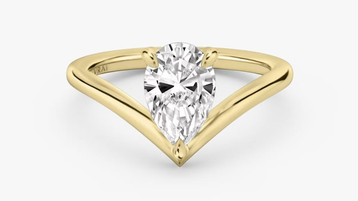 This modern and stylish design from VRAI has a V-shaped yellow gold band that delicately cradles a lab-grown pear-cut diamond.