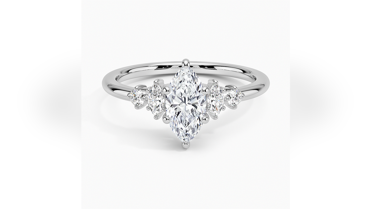 In this stunning ring, a marquise-cut diamond is nestled among shimmering round and marquise accent diamonds.
