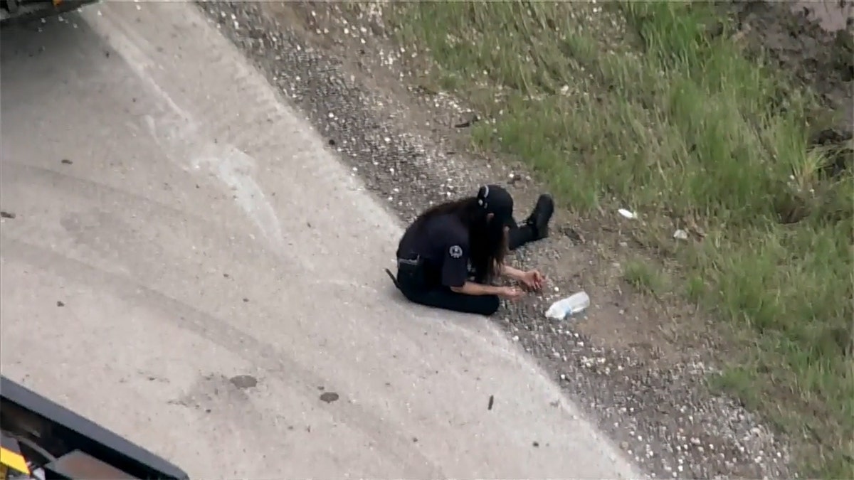 A woman picks up dimes individually at the scene.