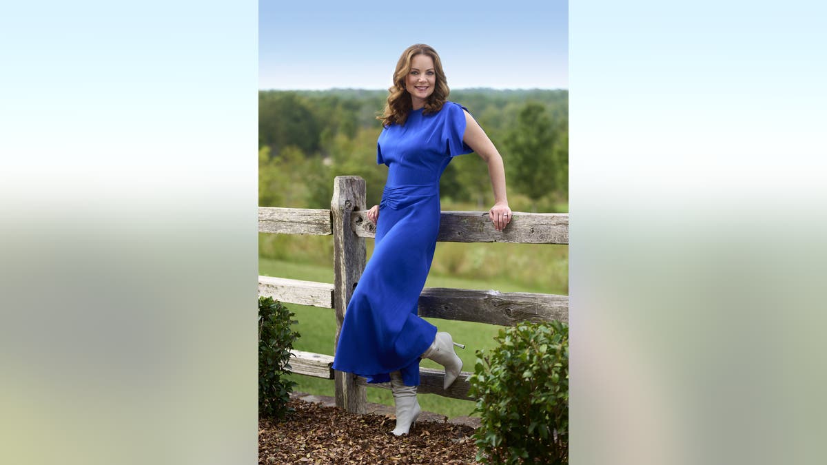 kimberly paisley-williams leaning against a fence in farmer wants a wife 
