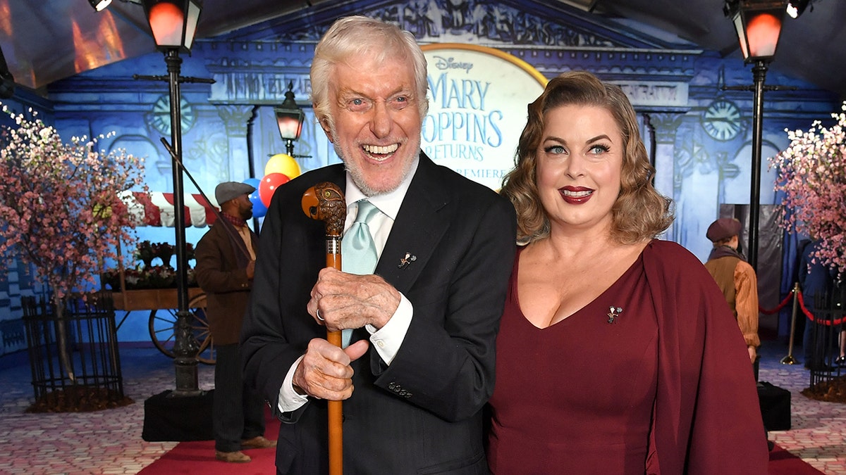 Dick Van Duke holding a cane and smiling next to his wife Arlene Silver