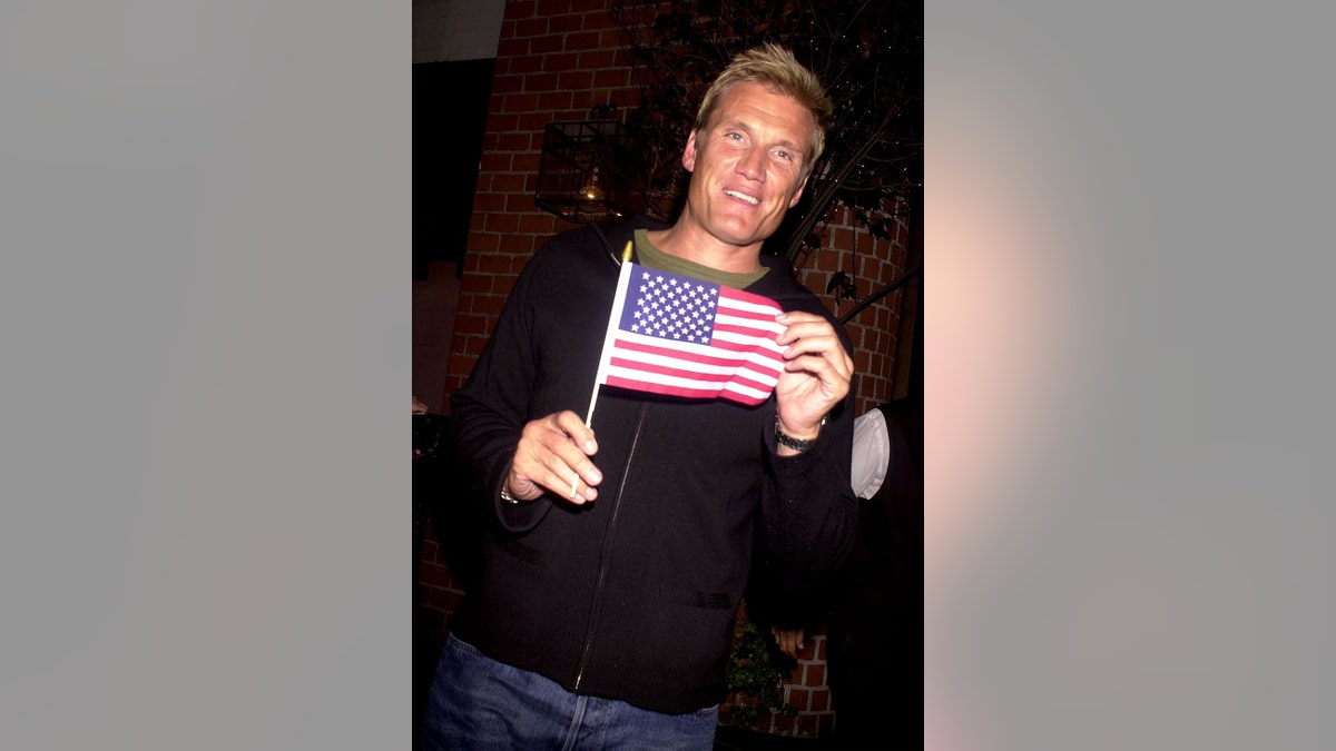 Dolph Lundgren holding an American flag.