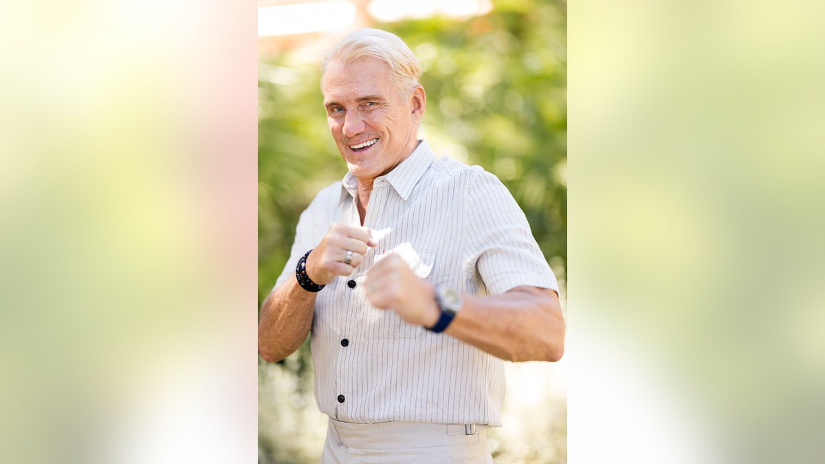 Dolph Lundgren in a fighting stance outdoors.