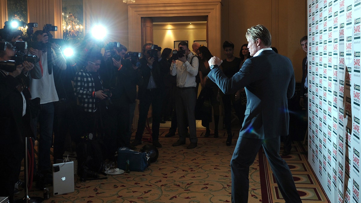 Dolph Lundgren in a punching stance in front of photographers.