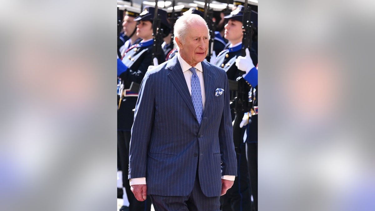 King Charles wears a suit that looks gloomy when he walks in front of his army.