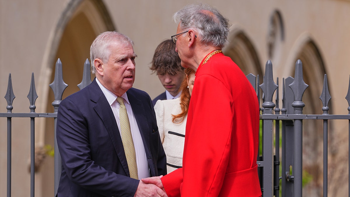 Prince Andrew shaking hands with a priest outside a church.