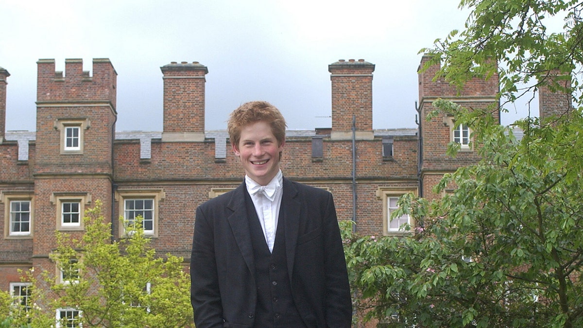 Prince Harry smiling in front of Eton College.