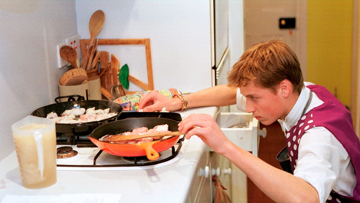 A young Prince William cooking in a school uniform.