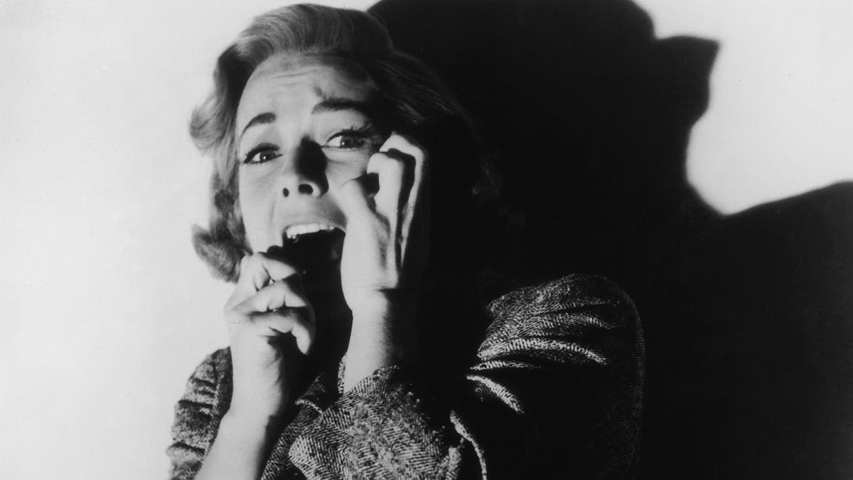 Vera Miles screaming and covering her face from a scene in Psycho.