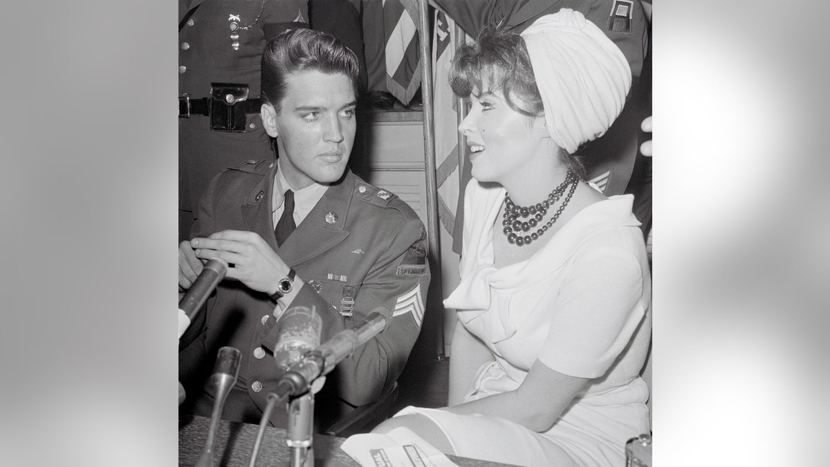 Tina Louise chatting with Elvis Presley in a uniform.