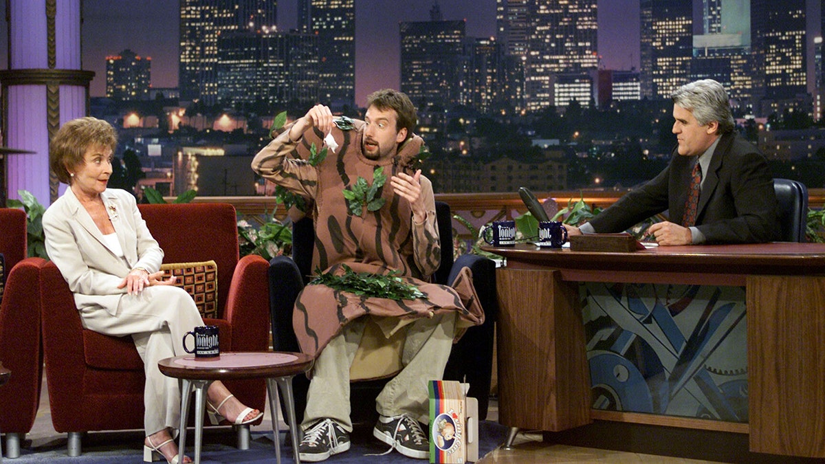 Tom Green holding a mouse while sitting in between Jay Leno and Judge Judy