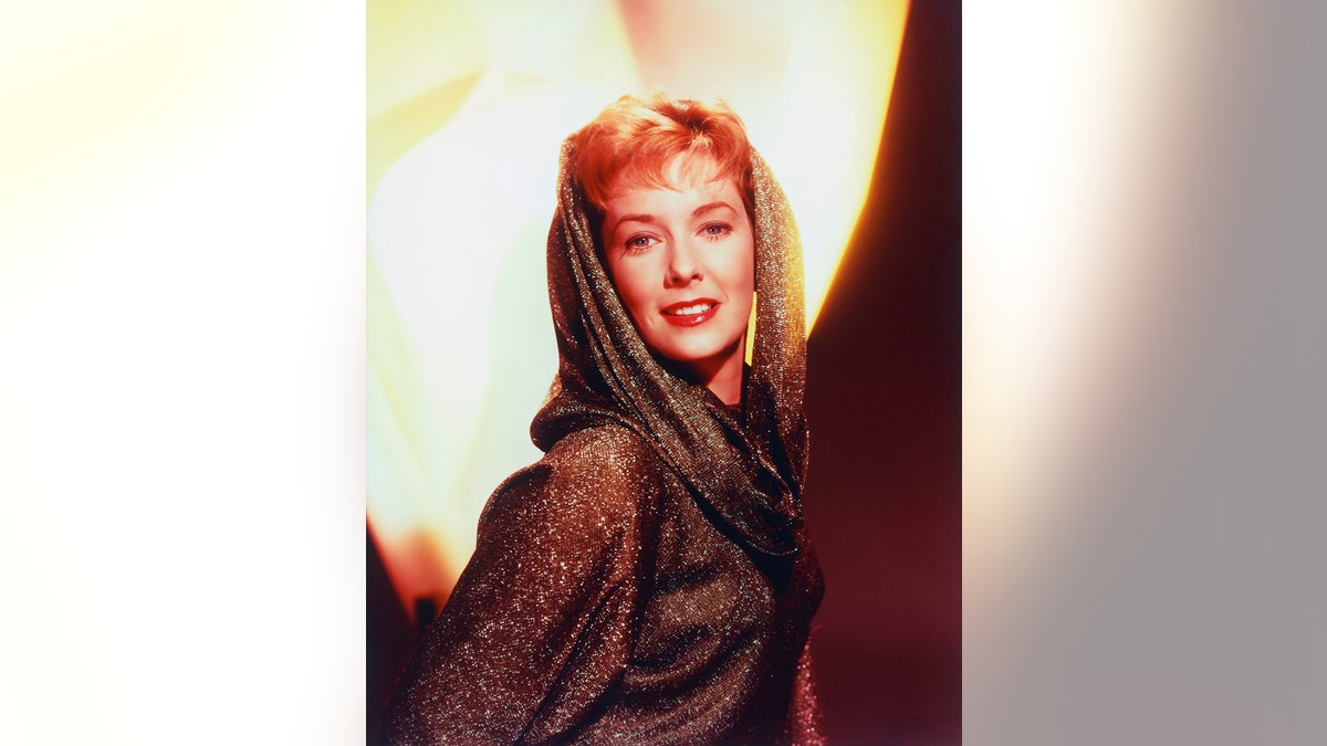 Vera Miles posing in a glamorous photo with the light behind her.