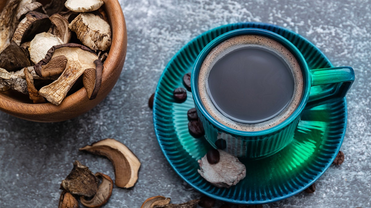 A cup of coffee with mushrooms and coffee beans