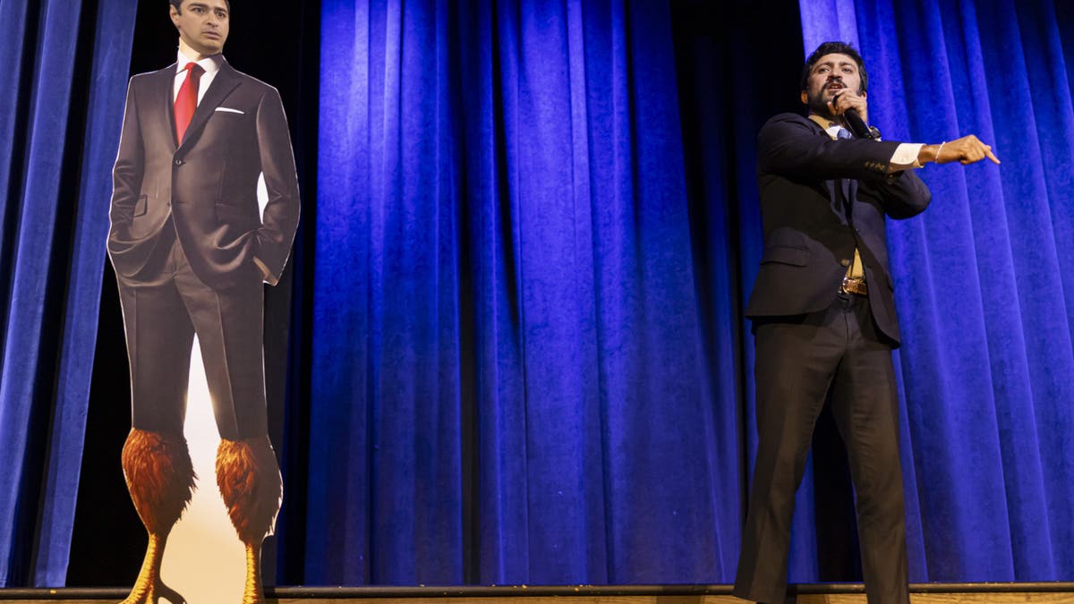 Rep. Greg Casar stands near a cardboard cutout of Republican Congressman Gabe Evans with chicken legs during a town hall meeting in Thornton on April 24, 2025.