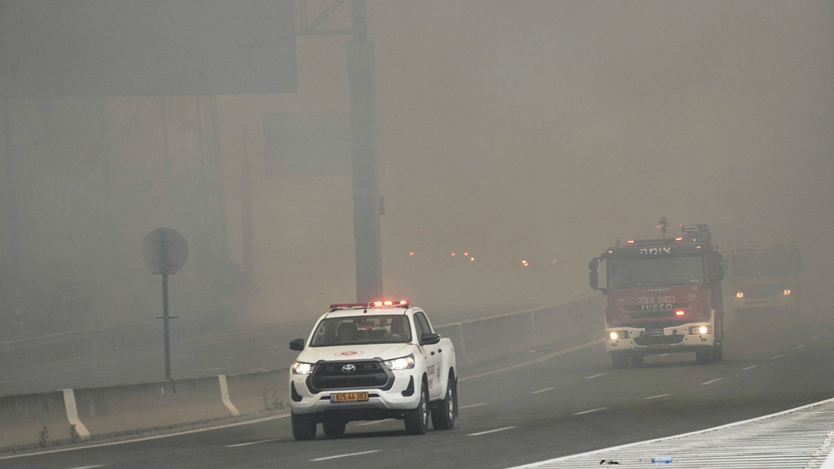 Israeli fire department crews drives through smoke from a burning fire on the freeway near Jerusalem, Wednesday, April 30, 2025. (AP Photo/Mahmoud Illean)