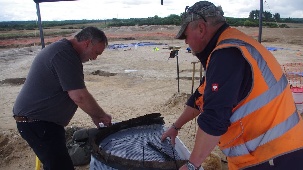 Archaeologists working with chariot wheel
