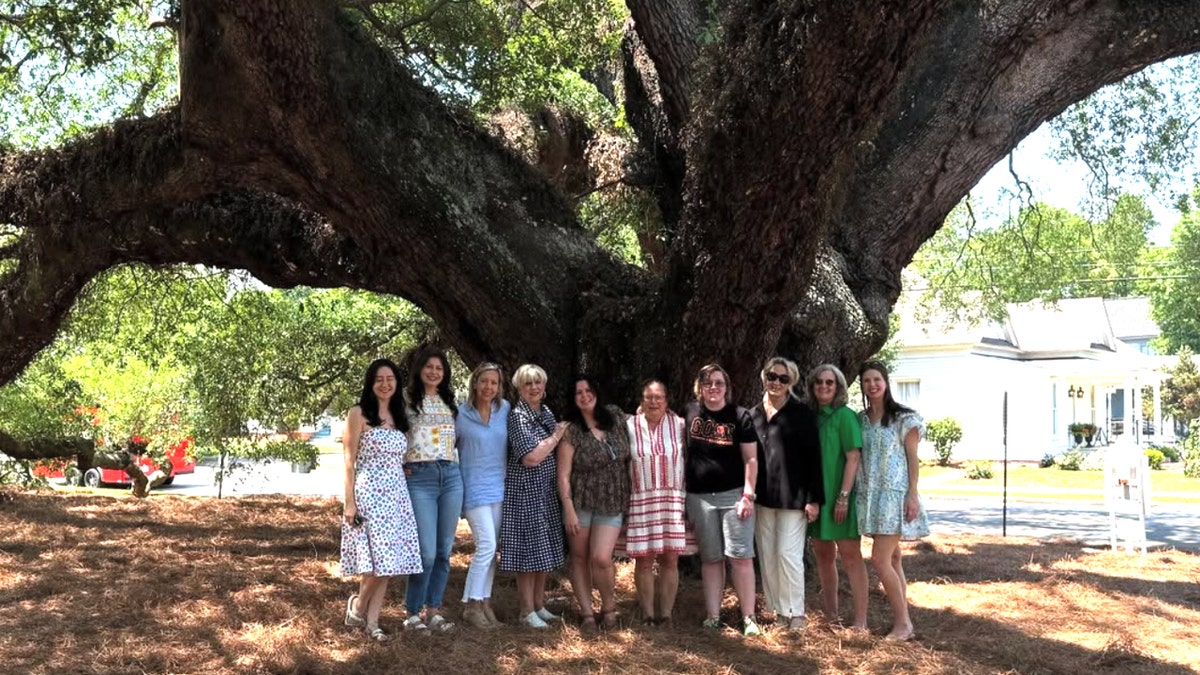 Ten women pose for a photograph in front of the "Big Oak" in Thomasville, Georgia.