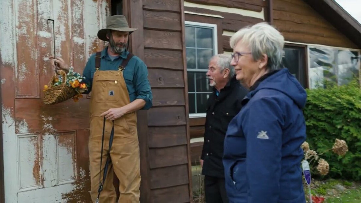 Tom Green showing a display on his door to his parents.