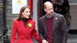 Kate Middleton in a red coat and Prince William in a red sweater