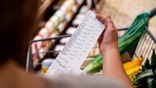 Person holding receipt while shopping at a grocery store.