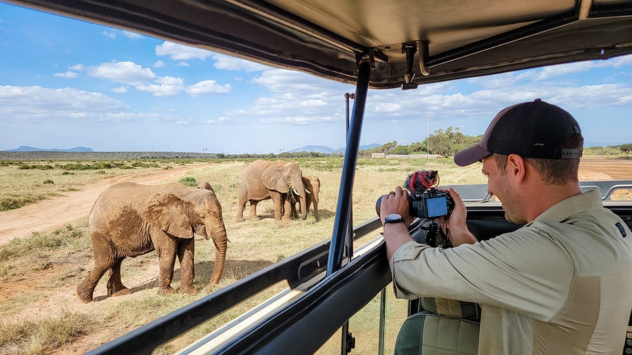 hudson taking photos of elephants on a safari in kenya