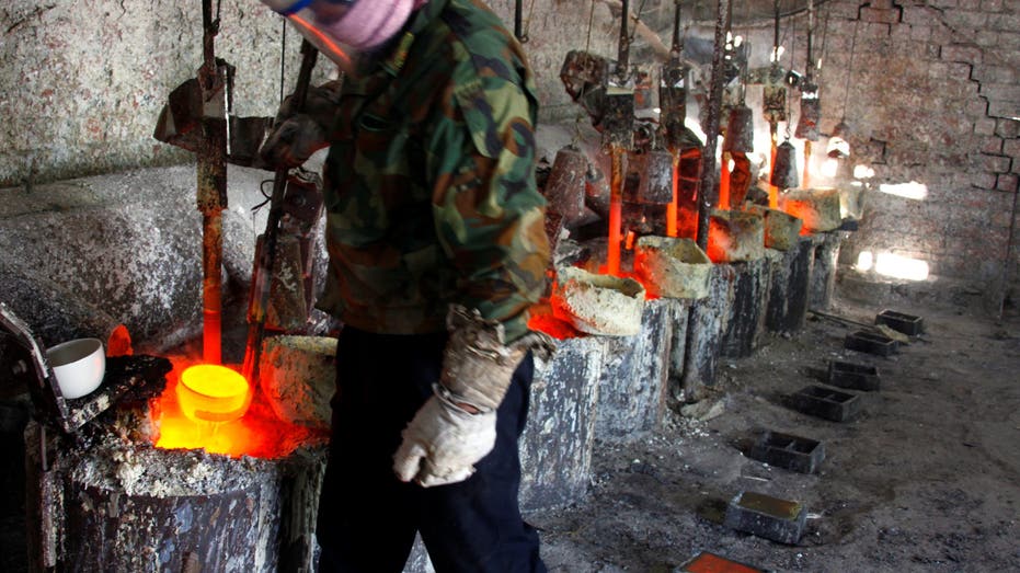 Ren Limin, a worker at the Jinyuan Company's smelting workshop, prepares to pour the rare earth metal Lanthanum into a mould near the town of Damao in China's Inner Mongolia Autonomous Region 