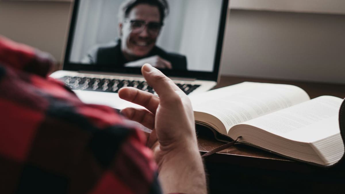 Illustration of a person video conferencing on their laptop.
