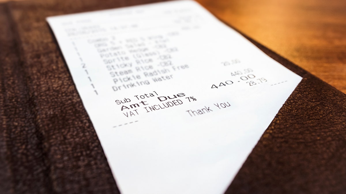 A $440 bill is shown on a table at a restaurant.