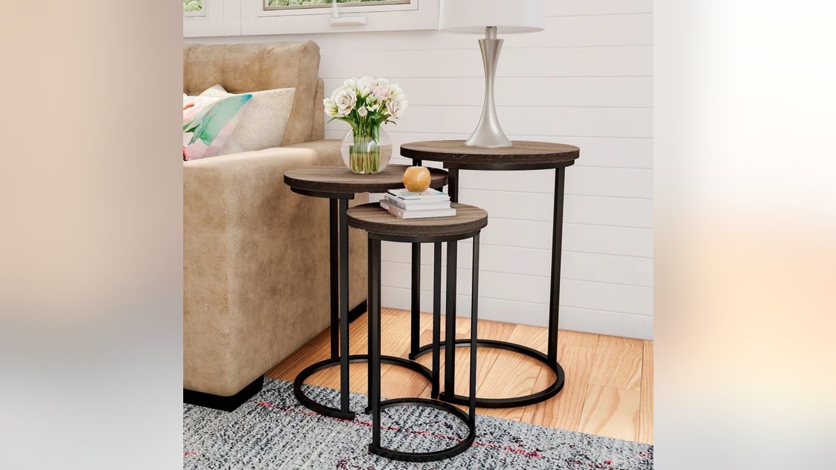 A set of three nesting side tables next to a couch