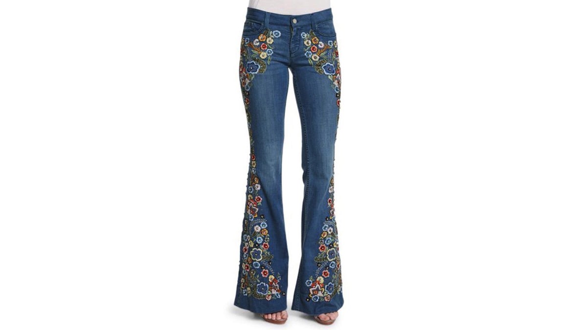 A pair of embroidered flared jeans on a white background