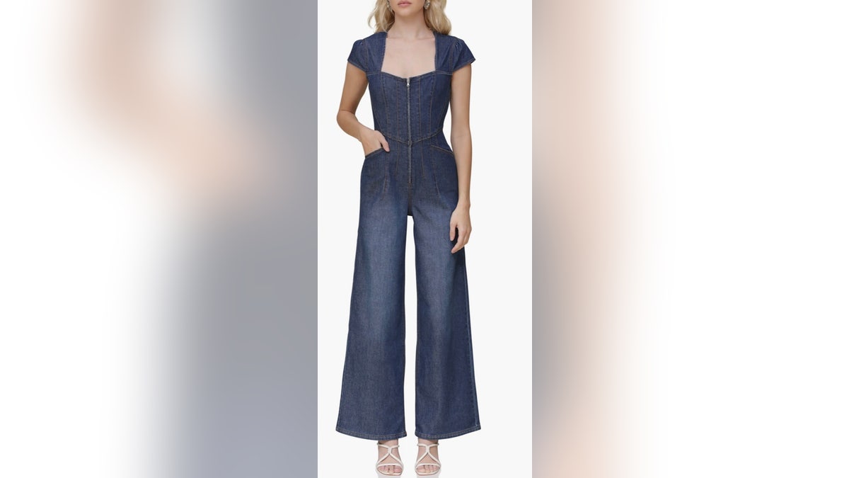 A exemplary wearing a wide-leg denim jumpsuit connected a achromatic background